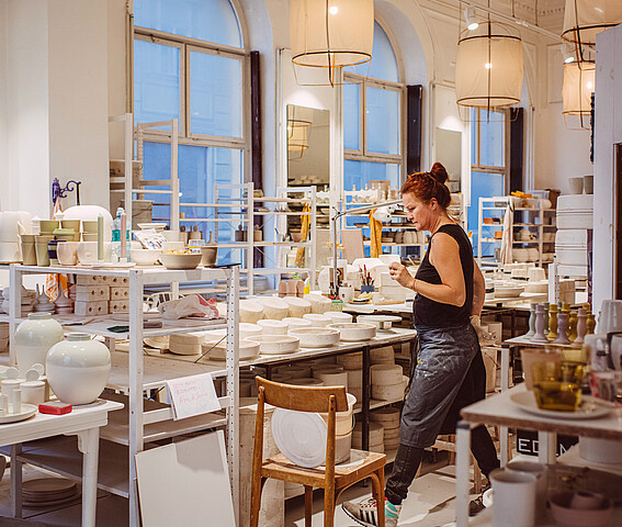 feinedinge: Eine Frau steht in einem Keramikatelier. 