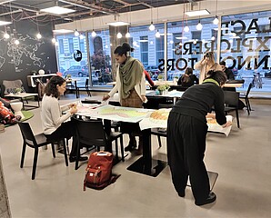 Diversity_ Frauen (drei im Vordergrund) beim Arbeiten beziehungsweise beim Malen Founders Lab Durchs