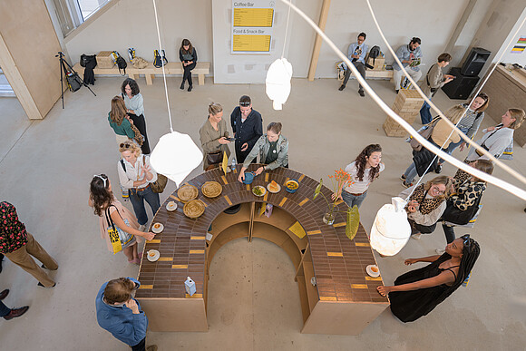 Food Innovation Personen, die um einen Tisch mit Essen stehen