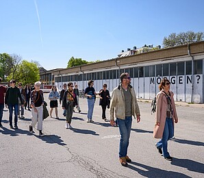 Mehrere Personen nehmen an Tour am Nordwestbahnhof Areal teil; gehen gemeinsam den Weg entlang