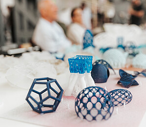 Formen aus dem 3D-Drucker unterschiedliche Blautöne auf weißer Oberfläche