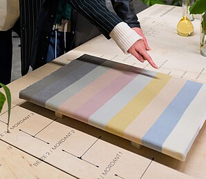 Sichtbar ist ein Strickstück, welches die verschiedenen "Wiener Farben" zeigt.