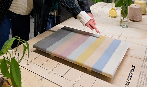 Sichtbar ist ein Strickstück, welches die verschiedenen "Wiener Farben" zeigt.