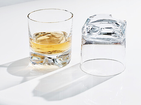 Lobmeyr: Zwei Gläser stehen auf einem Tisch. Eines davon ist zur Hälfte mit einer Flüssigkeit gefüllt
