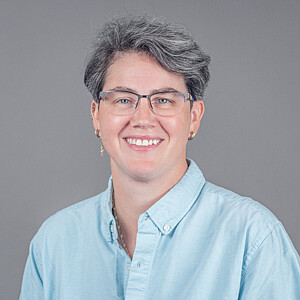Portrait von Claudia Farnik, eine Frau mit kurzen Haaren und Brille
