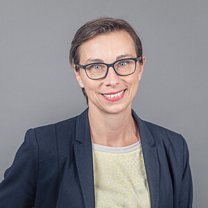 Porträt von Gabriele Tatzberger, eine Frau mit kurzem braunen Haar und Brille