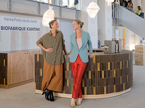 Biofabrique Vienna: Alice Jacubasch und Elisabeth Noever-Ginthör lehnen an der Theke der Biofabrique Kantine