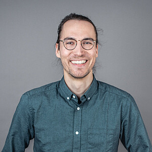 Portrait von Florian Hofer, einem Mann mit dunklen Haaren und Brille